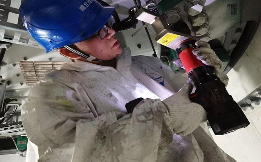 運維人員袁才波正在狹小的空間內打力矩（攝影：張鍵鍵）